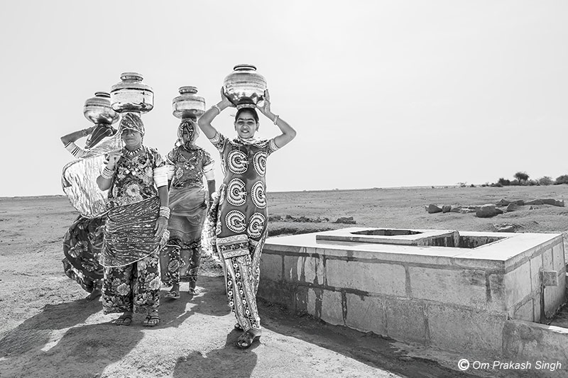 Carrying home pots full of drinking water from a <em>beri</em> in Netsi village, Thar Desert, Jaisalmer district, Rajasthan, India